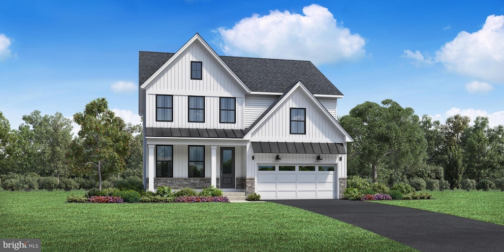 modern farmhouse featuring aphalt driveway, an attached garage, and a front yard