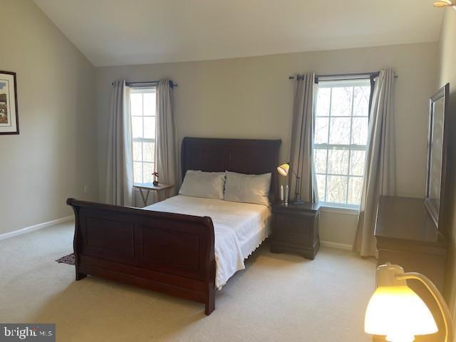 bedroom with baseboards, light colored carpet, and vaulted ceiling