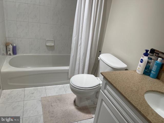 bathroom featuring tile patterned floors, toilet, vanity, and shower / bathtub combination with curtain