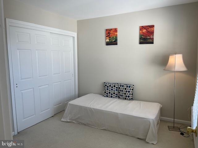 carpeted bedroom featuring a closet and baseboards