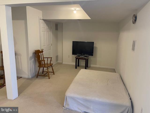 bedroom with visible vents, baseboards, and light carpet