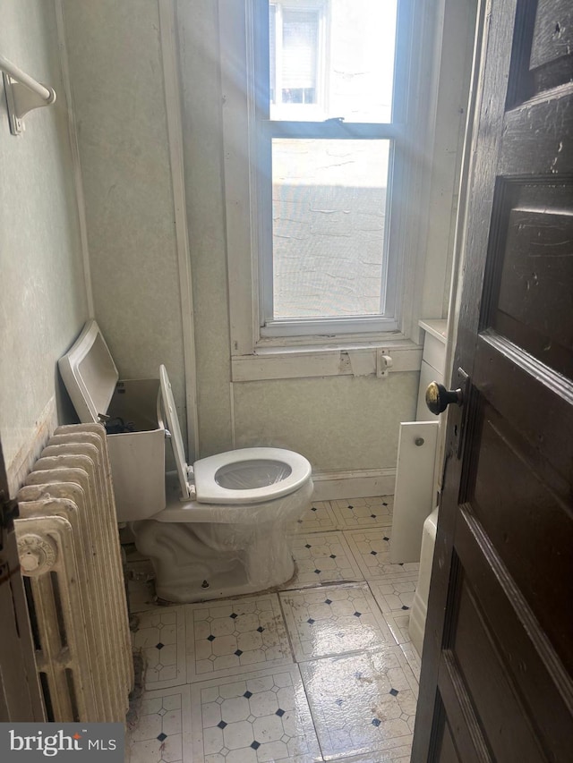 bathroom featuring toilet, tile patterned floors, and radiator heating unit