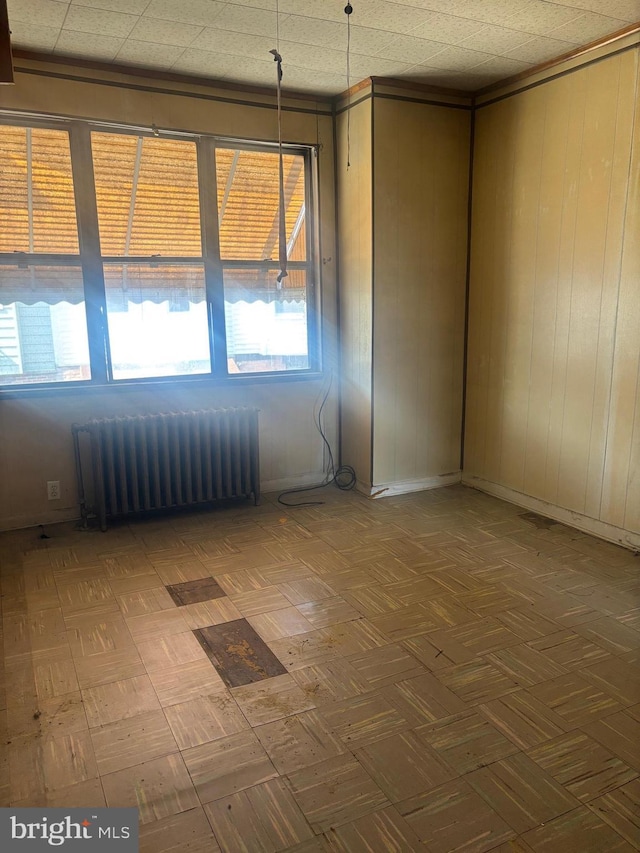 unfurnished room with radiator heating unit