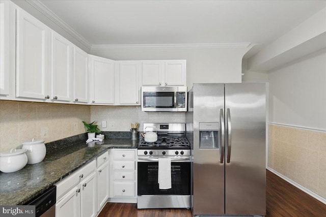 kitchen featuring dark stone counters, ornamental molding, stainless steel appliances, dark wood-type flooring, and white cabinets