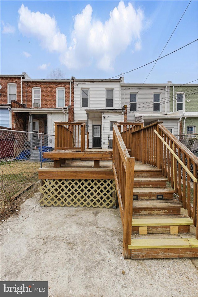 rear view of property with a deck and fence