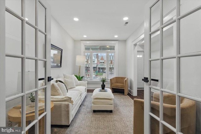 living area with visible vents, recessed lighting, french doors, and wood finished floors