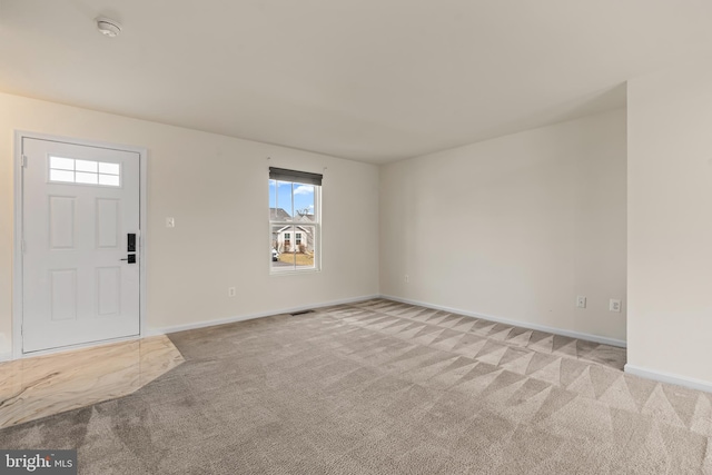 foyer with baseboards, light carpet, and visible vents