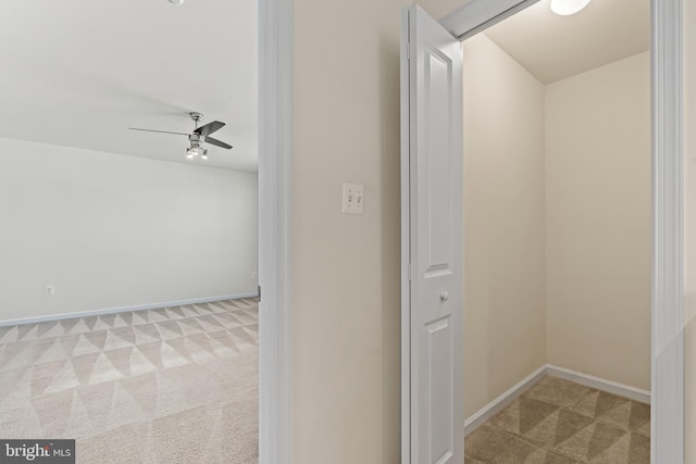 hall featuring baseboards and carpet floors