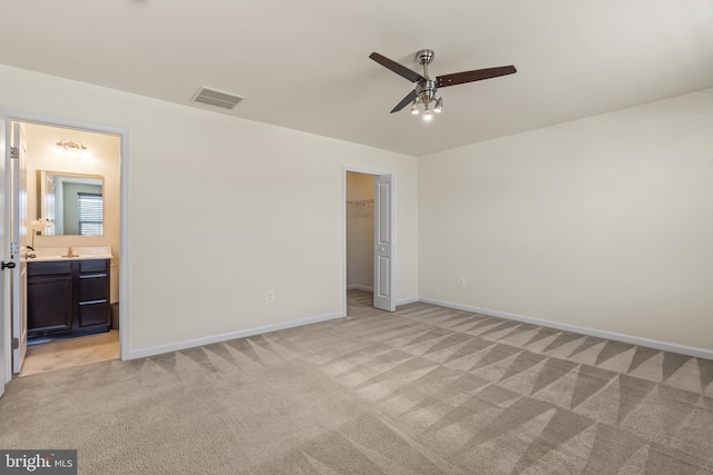 unfurnished bedroom featuring visible vents, baseboards, light colored carpet, and a spacious closet