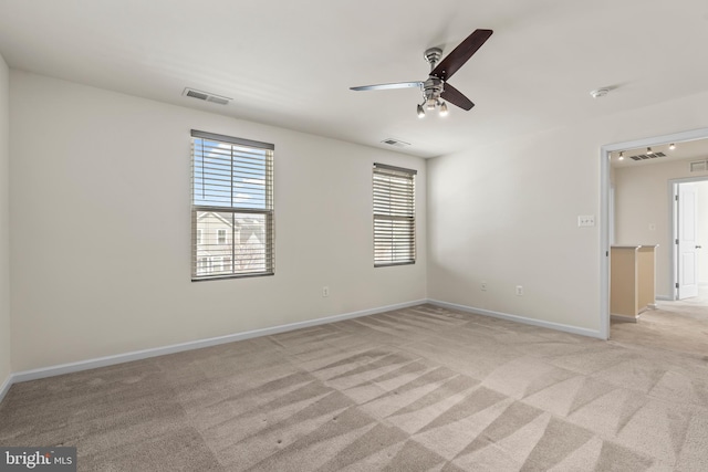 spare room featuring visible vents and light carpet