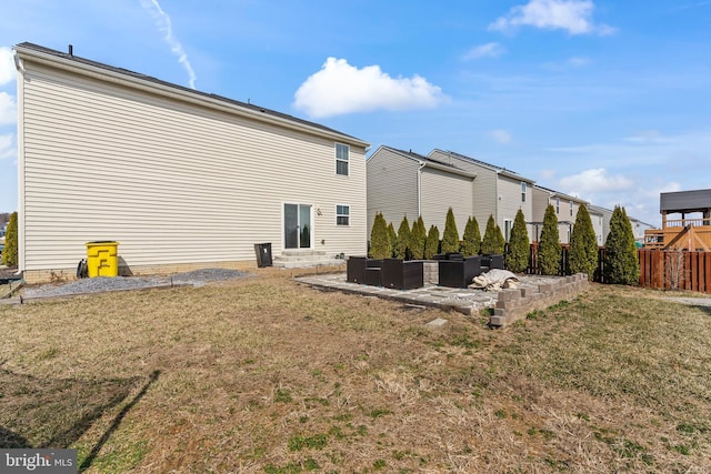 back of house featuring outdoor lounge area, a patio, a lawn, and fence