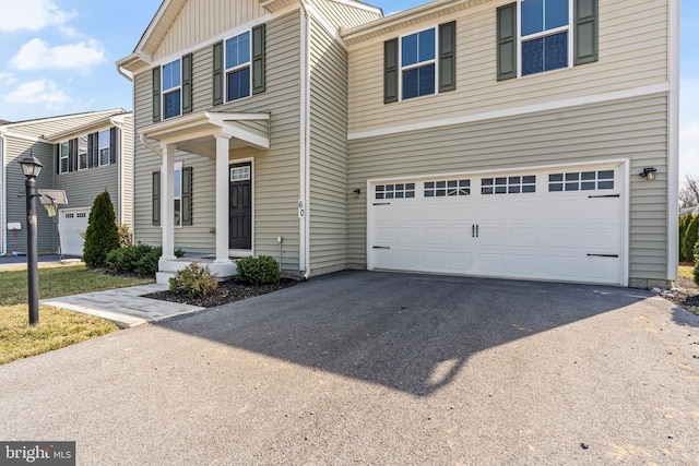 traditional-style home with board and batten siding, a garage, and driveway