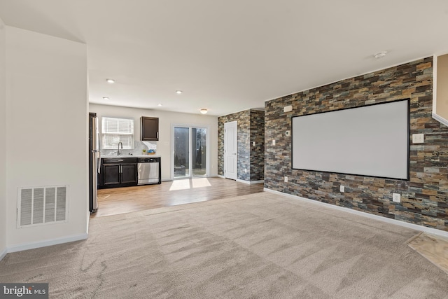 home theater room featuring visible vents, baseboards, light carpet, recessed lighting, and a sink