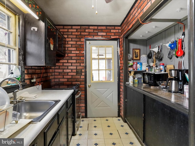 kitchen with a sink, stainless steel stove, brick wall, and black microwave