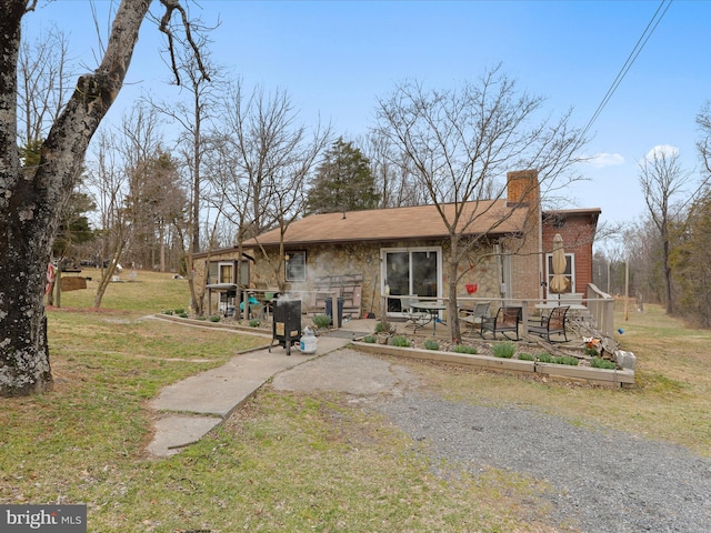 exterior space with a lawn, a chimney, and a patio