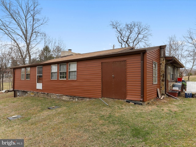 back of property with a chimney and a yard