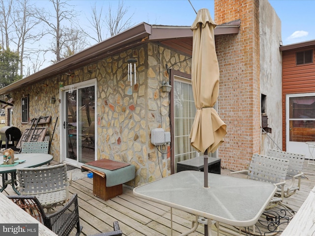 wooden deck with outdoor dining area and a grill