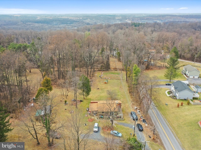 birds eye view of property featuring a rural view and a wooded view