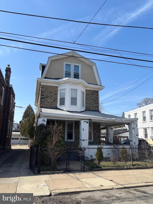 view of front of home featuring a fenced front yard, stucco siding, a porch, and a gate