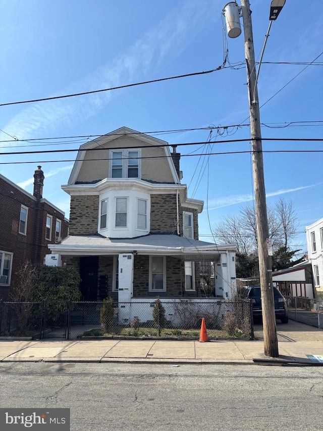 view of front of house featuring a fenced front yard and covered porch