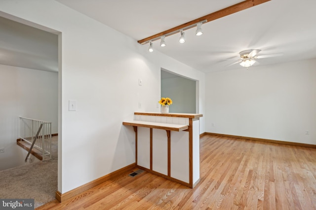 empty room featuring visible vents, baseboards, light wood-type flooring, and ceiling fan