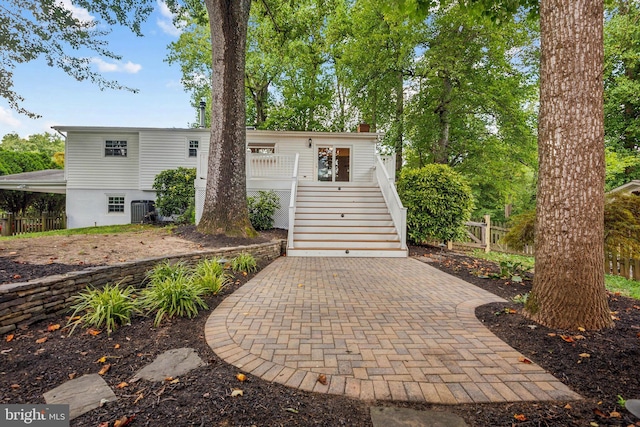 exterior space featuring cooling unit, a chimney, stairs, and fence