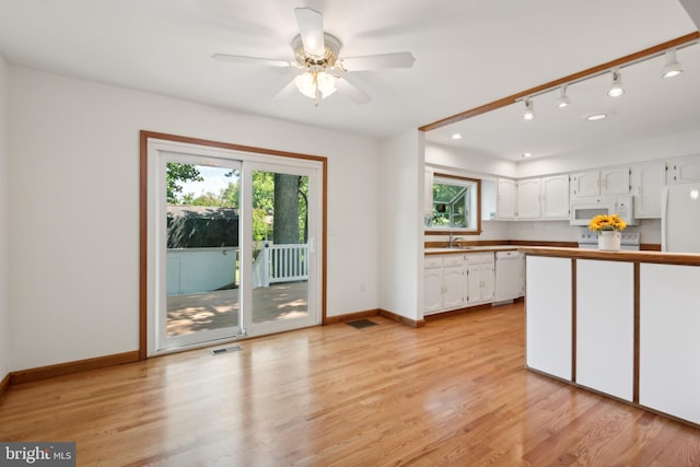 kitchen featuring light wood finished floors, visible vents, white appliances, and white cabinetry