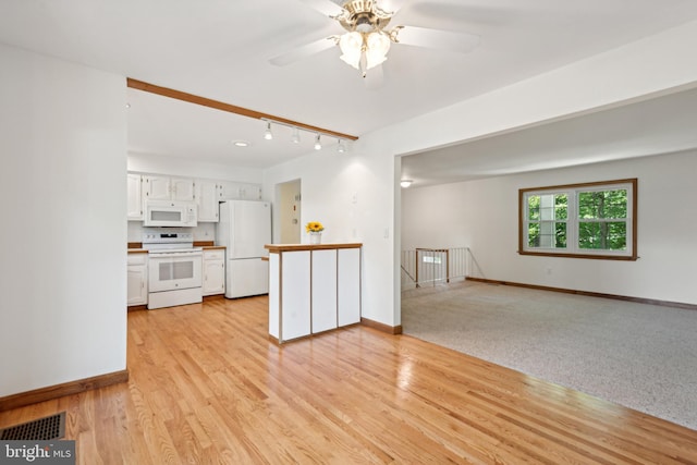 unfurnished living room featuring visible vents, baseboards, and ceiling fan