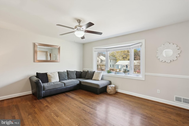 living area with a ceiling fan, wood finished floors, visible vents, and baseboards