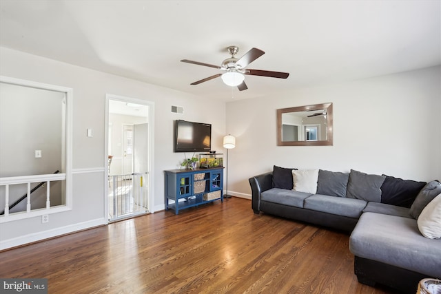 living area with visible vents, baseboards, ceiling fan, and wood finished floors