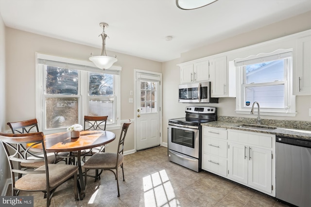 kitchen with a sink, a wealth of natural light, white cabinetry, and stainless steel appliances