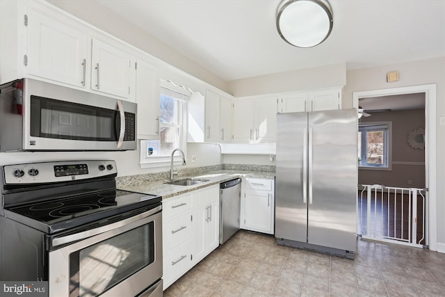 kitchen featuring a sink, appliances with stainless steel finishes, and white cabinetry