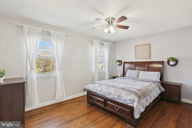 bedroom with baseboards, multiple windows, and dark wood-type flooring