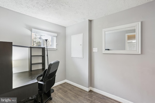 office area featuring baseboards, a textured ceiling, and wood finished floors