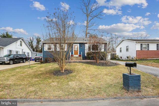 ranch-style home with driveway and a front yard