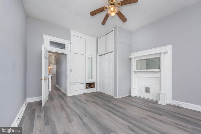 unfurnished bedroom with a closet, a ceiling fan, baseboards, and wood finished floors