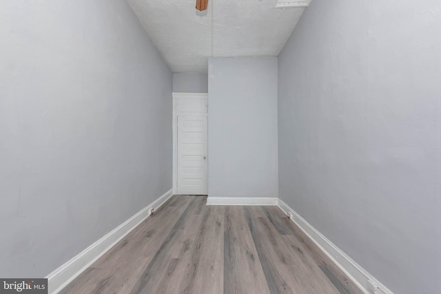 spare room featuring baseboards and wood finished floors
