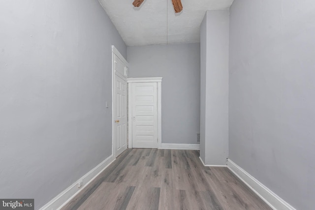empty room with a ceiling fan, wood finished floors, and baseboards