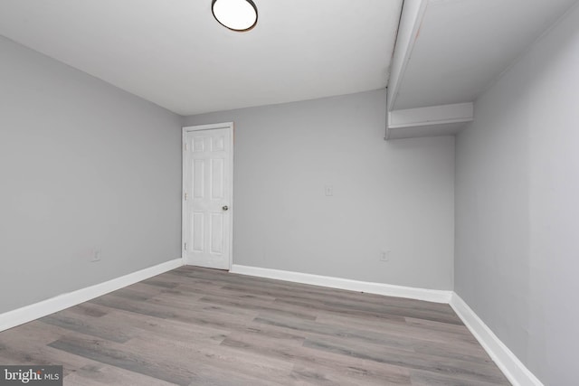 empty room with baseboards and wood finished floors