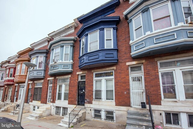 view of front facade with brick siding and entry steps