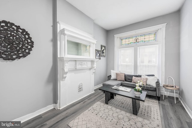 living area with baseboards and wood finished floors