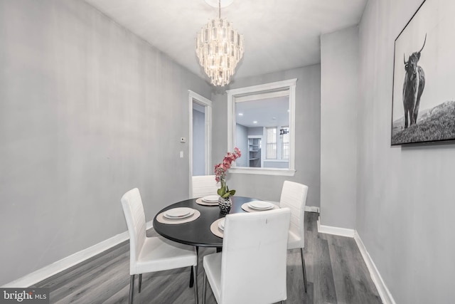 dining area featuring an inviting chandelier, wood finished floors, and baseboards