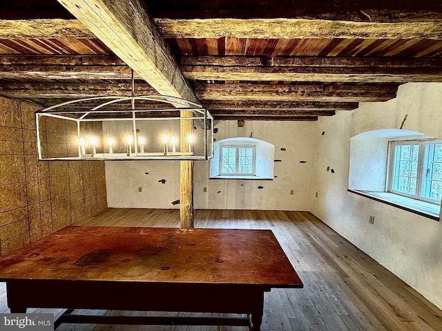 unfurnished living room featuring beamed ceiling, wood ceiling, and hardwood / wood-style floors