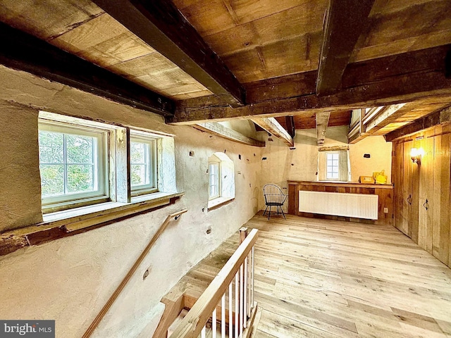 interior space with wood ceiling, wood-type flooring, beam ceiling, and radiator heating unit