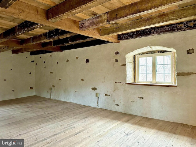 spare room with beam ceiling, wood ceiling, and hardwood / wood-style flooring