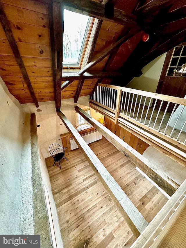 stairs with visible vents, wood-type flooring, wooden ceiling, and lofted ceiling with skylight