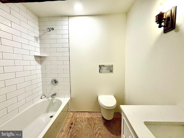 bathroom featuring tub / shower combination, toilet, vanity, and wood finished floors