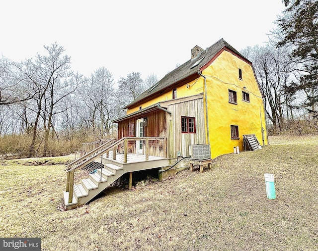 view of side of home featuring a wooden deck and a chimney