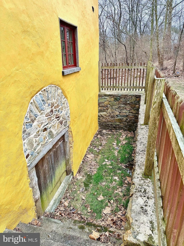 view of home's exterior with fence and stucco siding