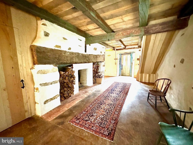 living area featuring wooden ceiling, beamed ceiling, and a fireplace